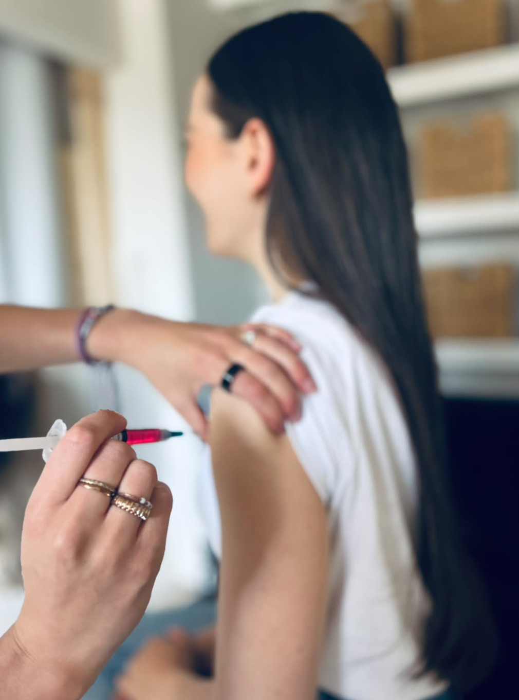Katie administering a vitamin injection to a client
